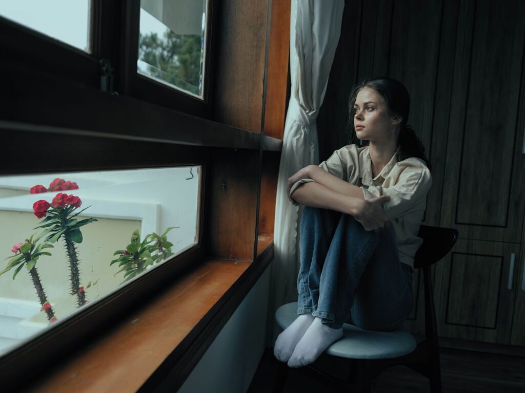 Young woman sitting alone, struggling with fear of being forgotten.