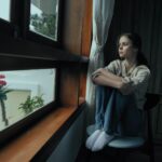 Young woman sitting alone, struggling with fear of being forgotten.